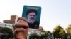 IRAN - A supporter of Iranian ultraconservative presidential candidate Ebrahim Raisi raises his portrait during a rally in the capital Tehran, on June 16, 2021