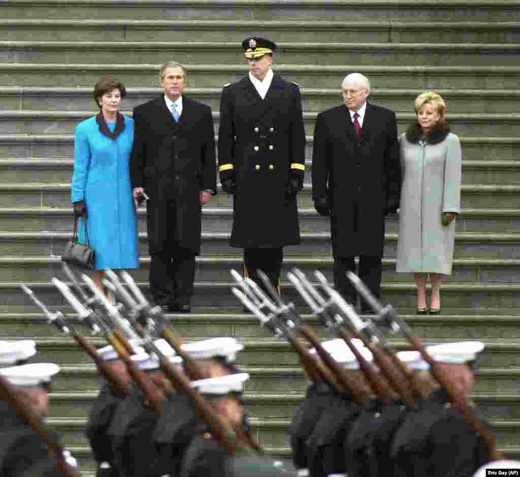 Prezident kiçi Jorj W. Buş we onuň aýaly Lora (çepde) 2001-nji ýylyň 20-nji ýanwarynda kasam kabul ediş dabarasyndan soň, wise-prezident Dik Çeni we onuň aýaly Linn (sagda) bilen Kapitolyň basgançagynda. Buş iki möhlete prezident boldy. &nbsp;