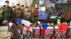 Një kolazh fotografish që përfshijnë militarizimin e fëmijëve ukrainas në territoret e pushtuara nga Rusia në Ukrainë.