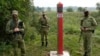 Belarusian guards stand at the border between Poland and Belarus in Krynki, Poland, on August 31.