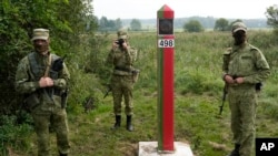 Belarusian guards stand at the border between Poland and Belarus in Krynki, Poland, on August 31.
