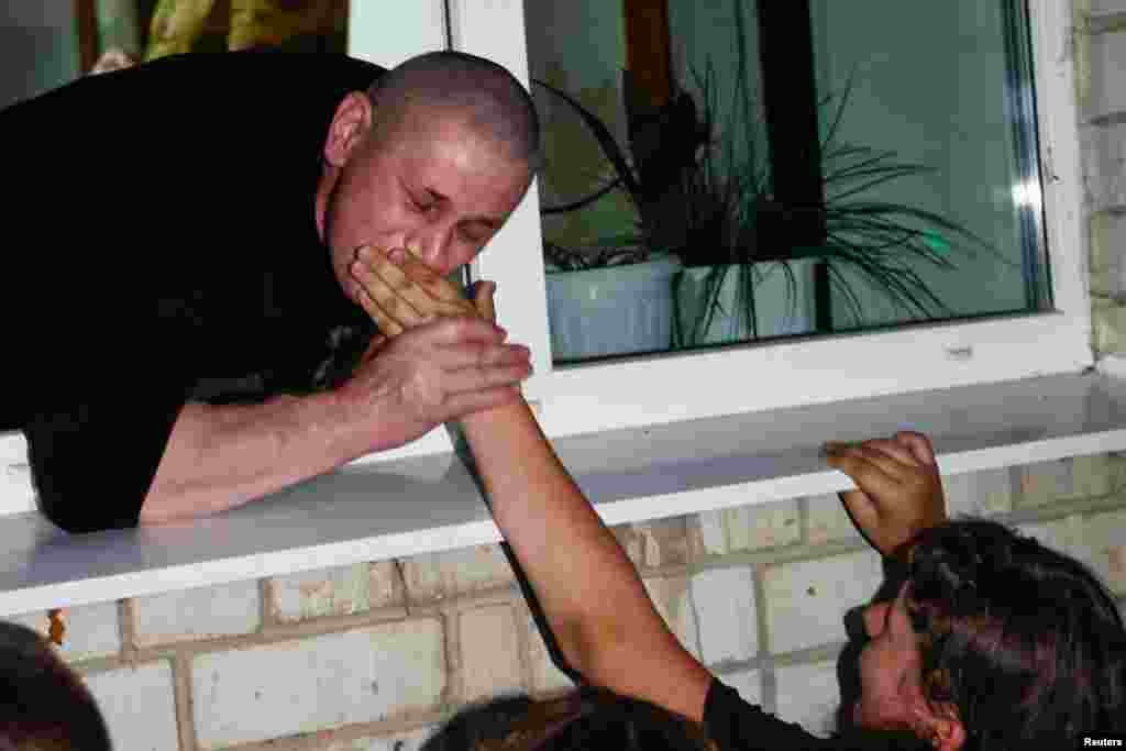 A Ukrainian POW kisses the hand of his daughter after a prisoner swap with Russia. 