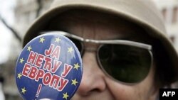 Žena koja tokom protesta u Beogradu drži bedž "Ja neću u Evropu" 