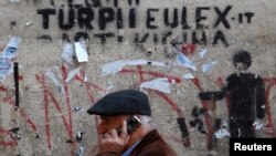 Čovek prolazi ispred grafita "Sramota EULEX-a" u Prištini