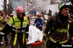 Спасатели выносят тело с места обрушения жилого дома, Киев, Украина, 31 июля 2025 года