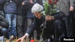 John Kerry punând lumânări la Kiev lângă monumentul improvizat al celor căzuți în timpul manifestațiilor.
