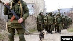Militari ruși în fața unei baze militare ucrainene lângă Simferopol.