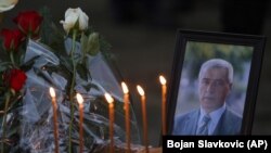 Lule dhe qirinj të vendosur pranë fotografisë së politikanit të vrarë serb, Oliver Ivanoviq.