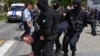 Полицейский спецназ тащит задержанного во время несанкционированной акции в Алматы с требованием «освободить политических заключенных». 10 мая 2018 года.