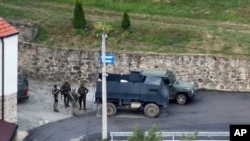 Në këtë fotografi të ofruar nga Policia e Kosovës, një grup burrash të armatosur dhe të maskuar qëndrojnë përpara Manastirit të Banjskës në të njëjtin fshat në veri të Kosovës, më 24 shtator 2023.